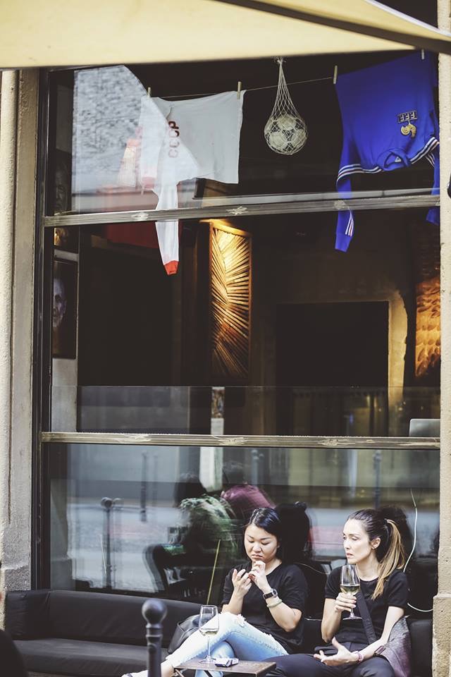 Maglie appese in vetrina con partita in TV